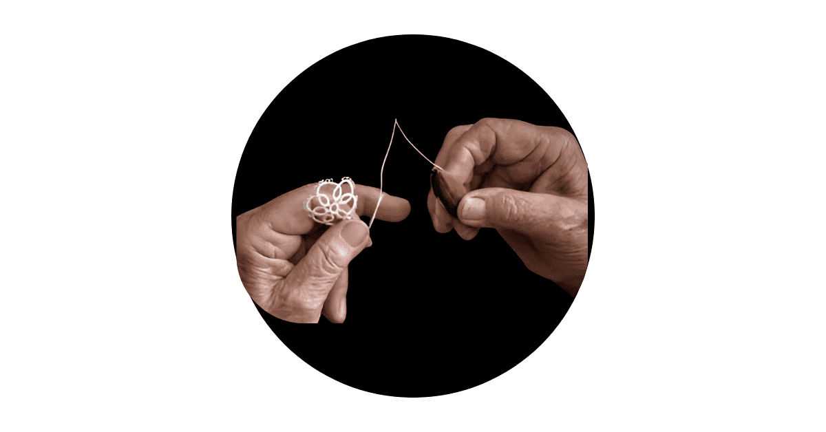 two hands holding tools and making a handcrafted earring