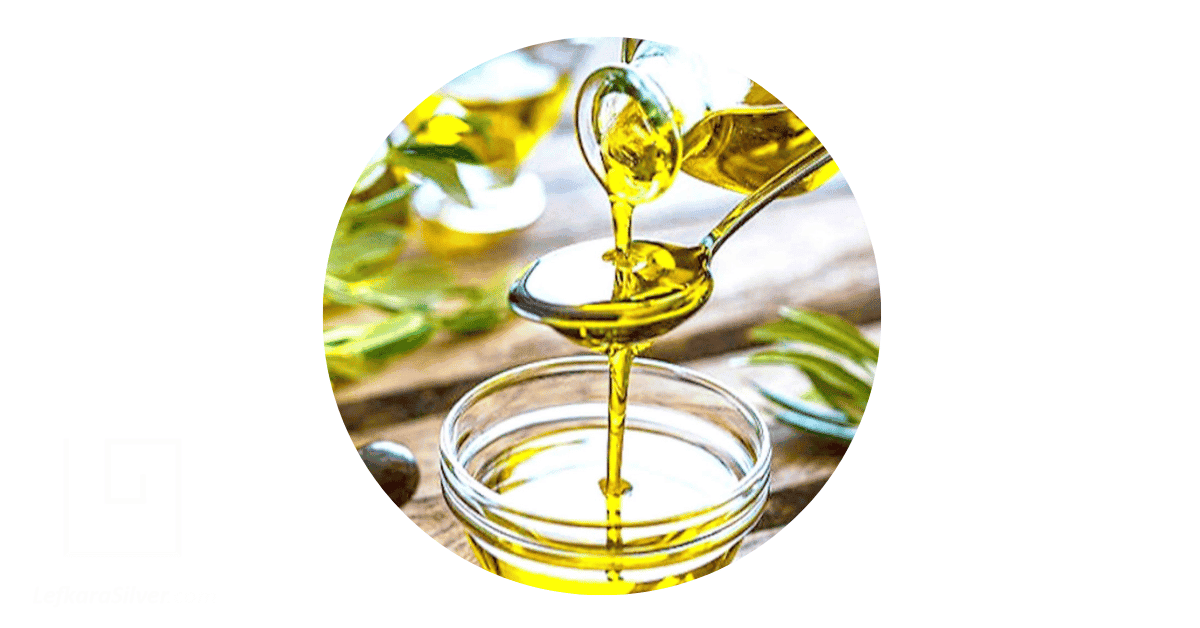 Olive oil being poured into a glass jar