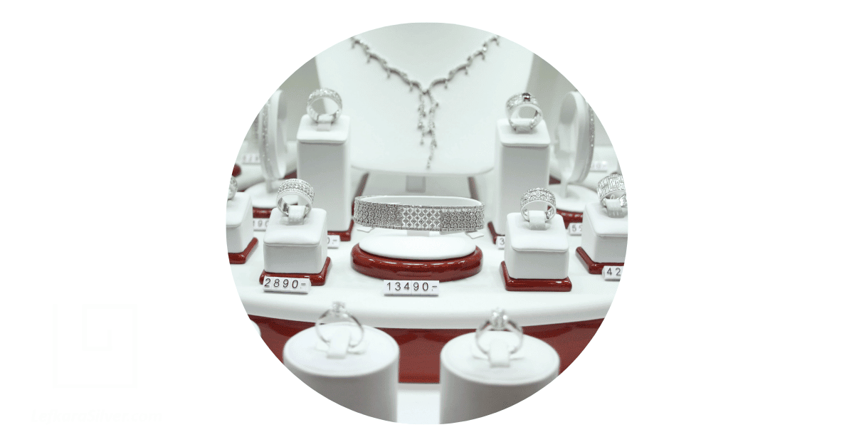 several silver jewelry on display in a store