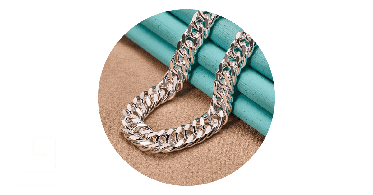 A sterling silver chain draped on a plain background