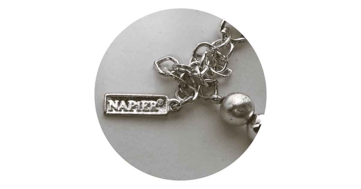 a silver necklace jewelry with the Napier trademark on it