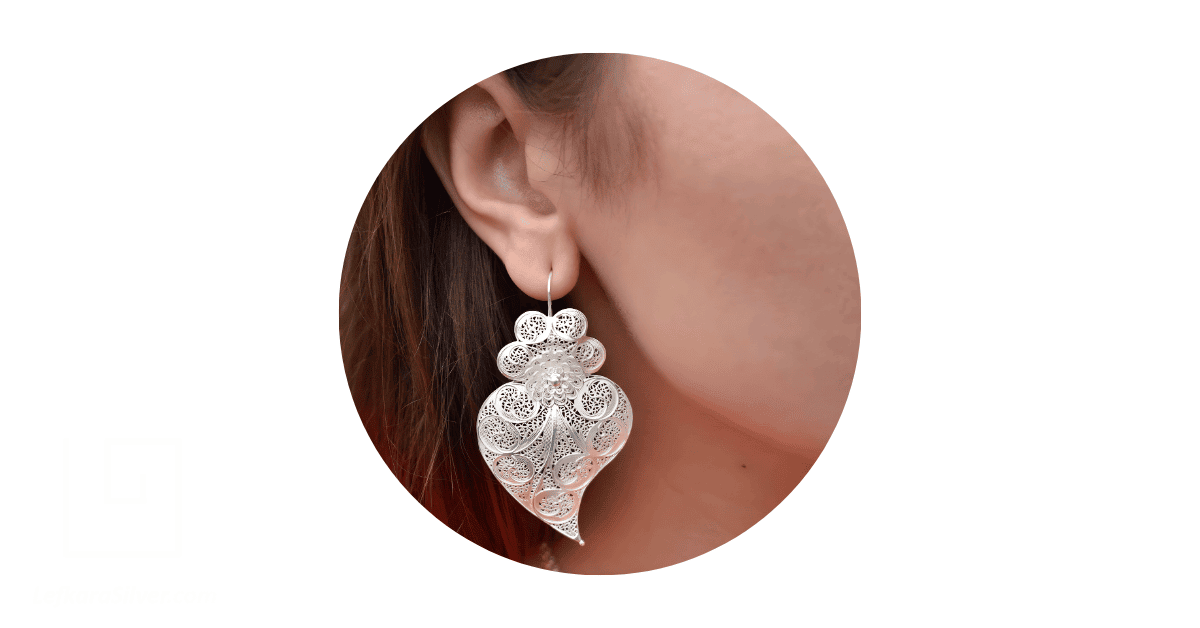 A woman wearing a silver filigree earring.