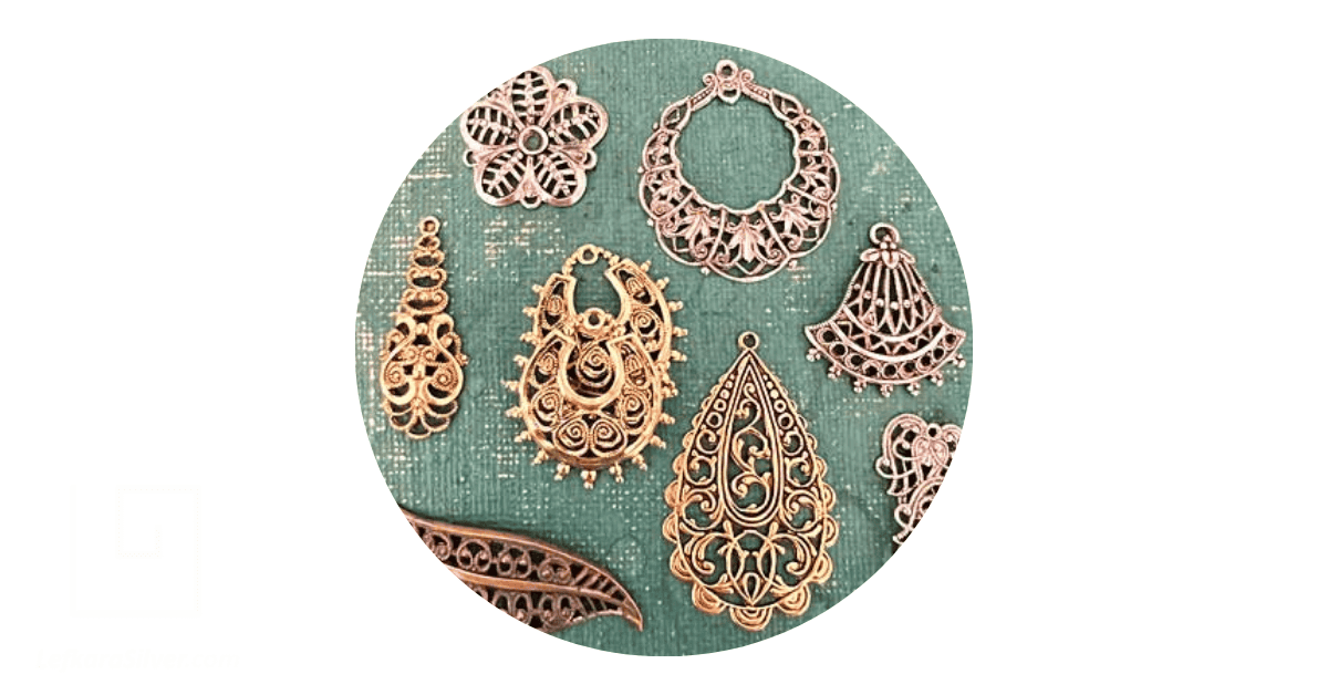 a set of filigree wholesale findings on a light blue background