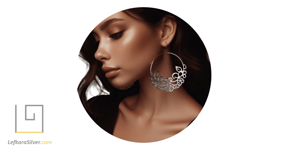 a young woman wearing trendy filigree hoop earrings, her head turned to the side to show off the earrings.
