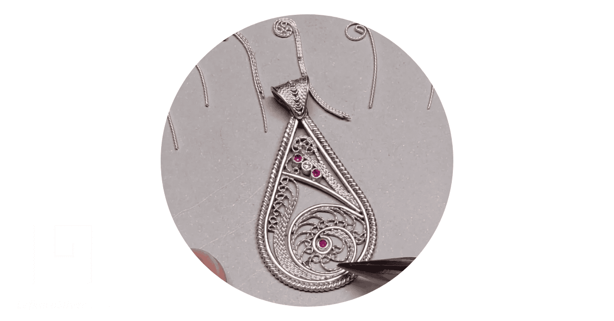 a jeweler making a silver filigree earring