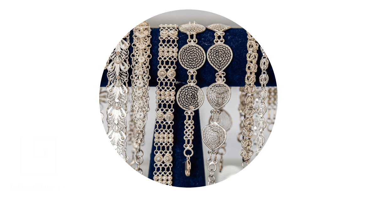 several filigree necklaces dangling on a rail