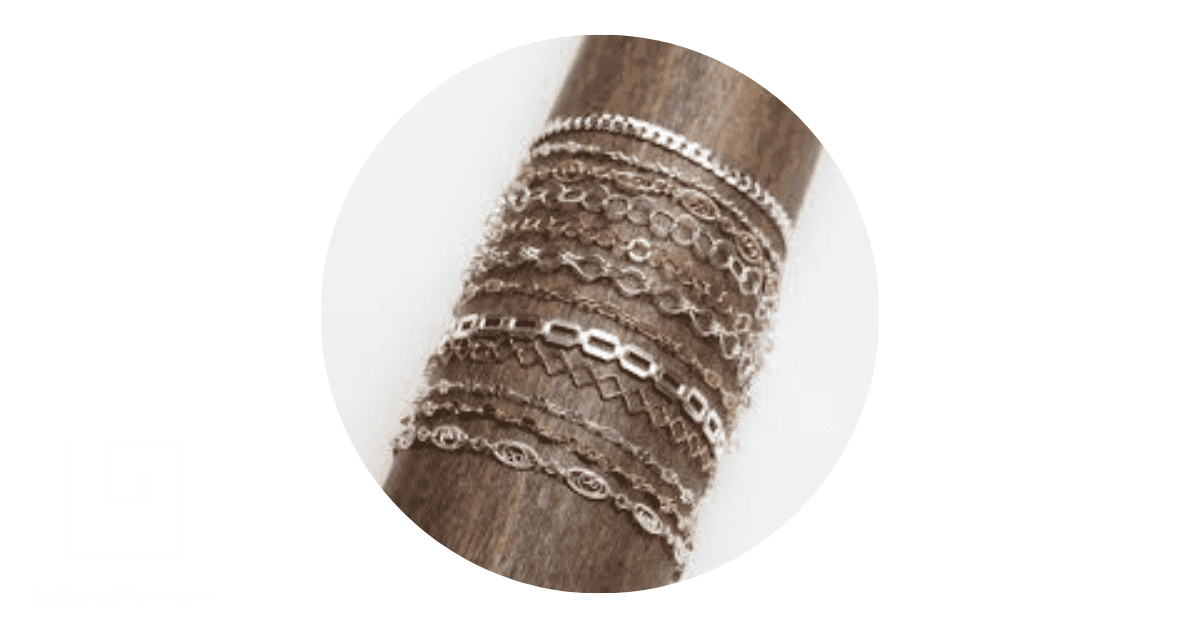delicate filigree bracelets wrapped around a log of wood
