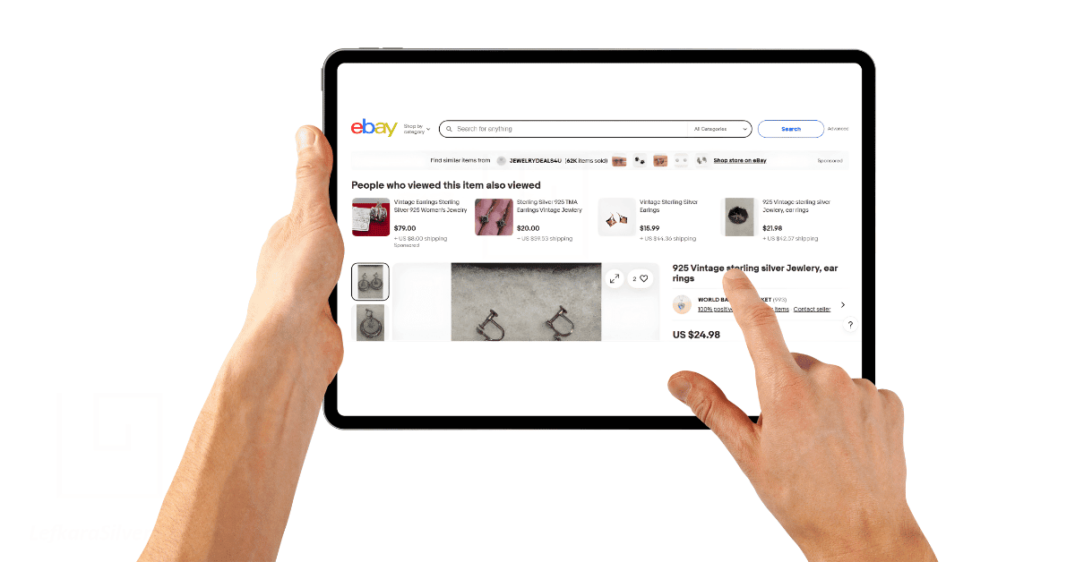 a person's hands browsing through eBay on their tablet for vintage silver jewelry