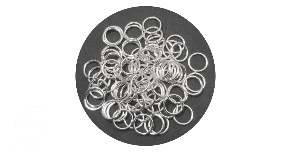 a collection of silver plated rings on a grey background