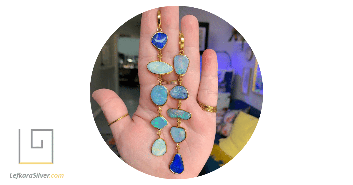a pair of earrings with several opals