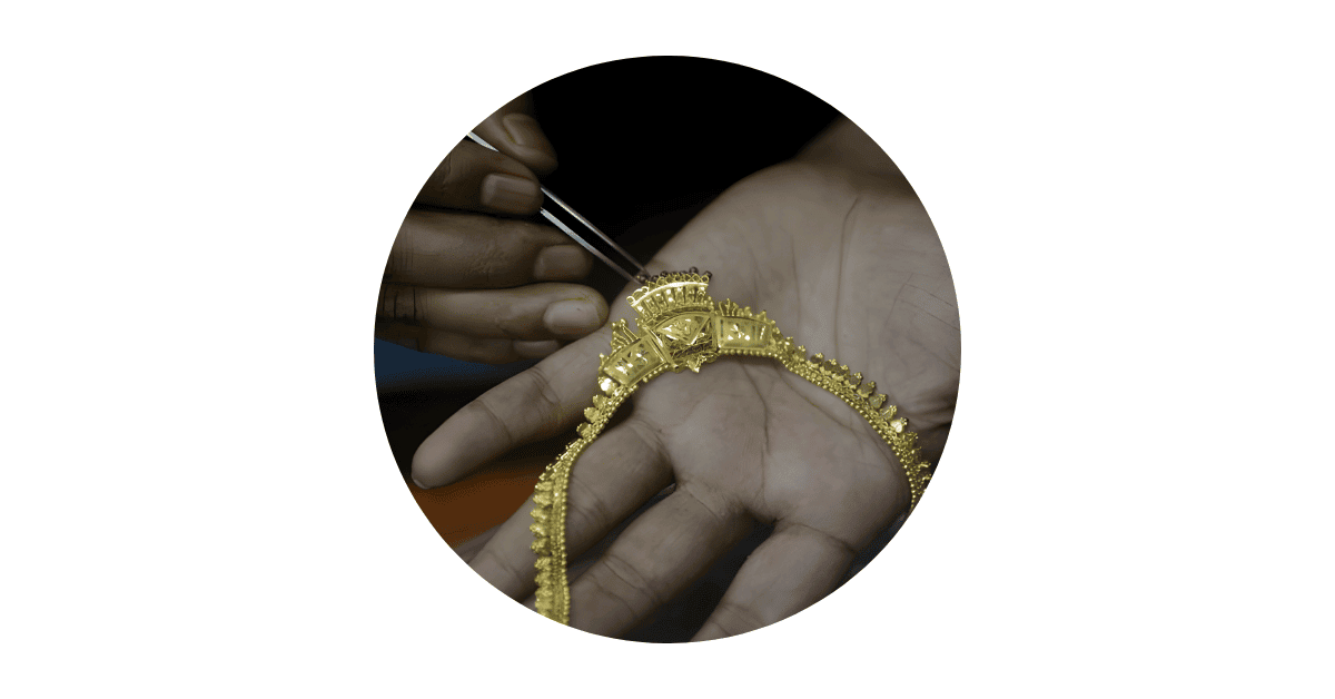 an artisan working on a gold necklace. 