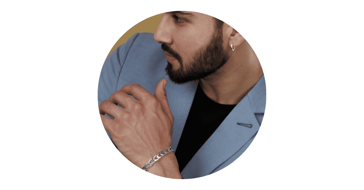 a man stylishly wearing silver hoop earrings and chain bracelet