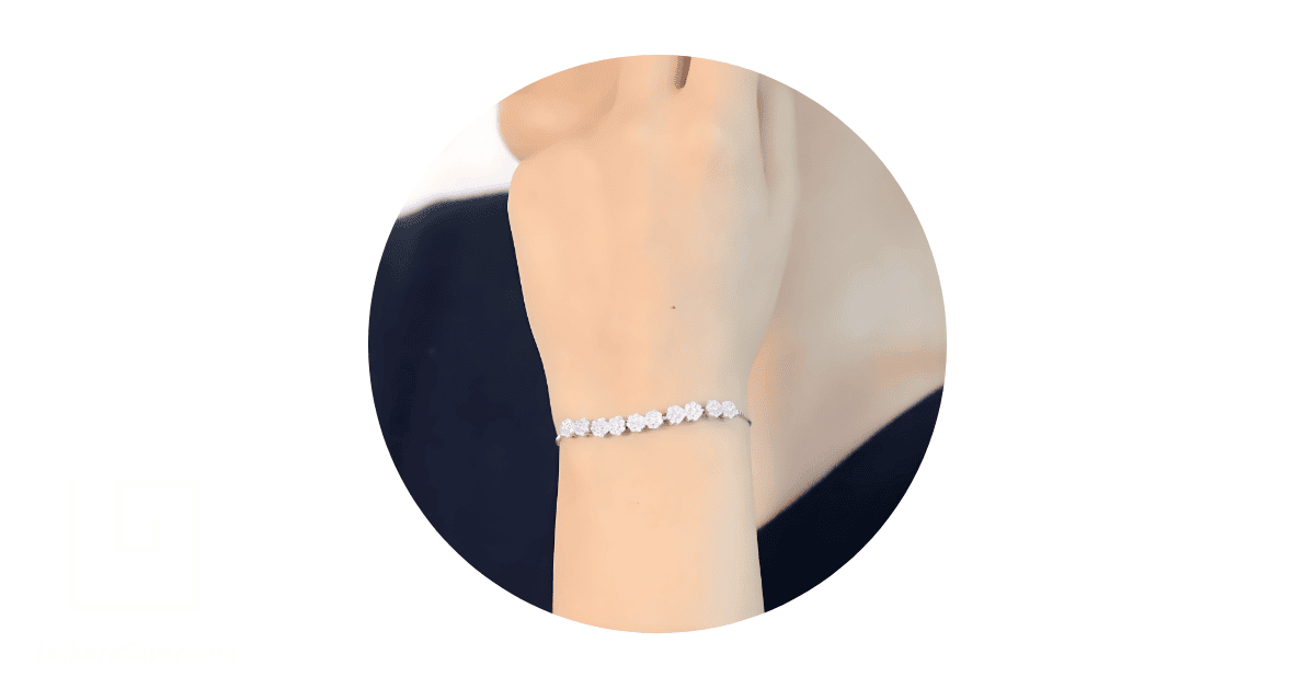 a person's wrist adorned with a beautiful silver bracelet.