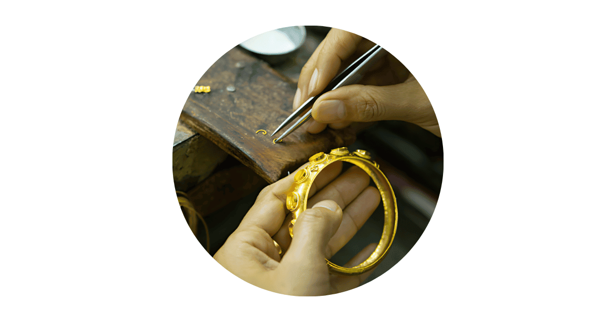 An artisan working on a gold bracelet. 