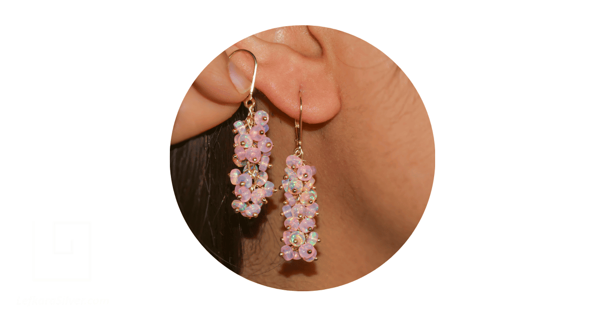 A woman's ear adorned with an opal bead earring.