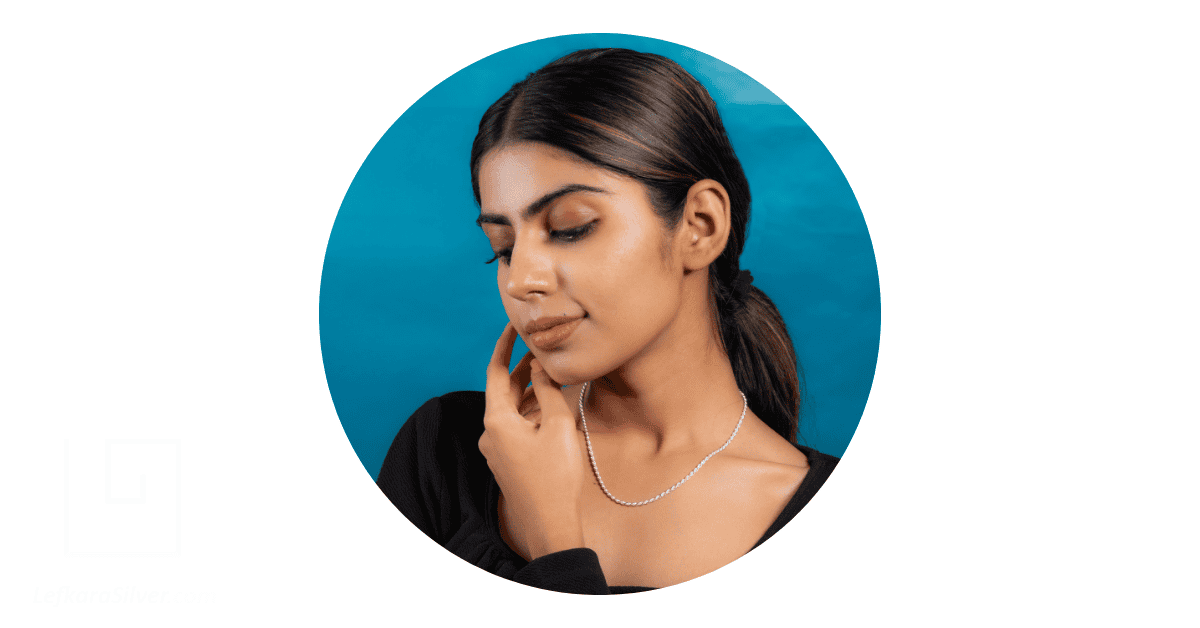 a woman wearing a simple silver chain necklace