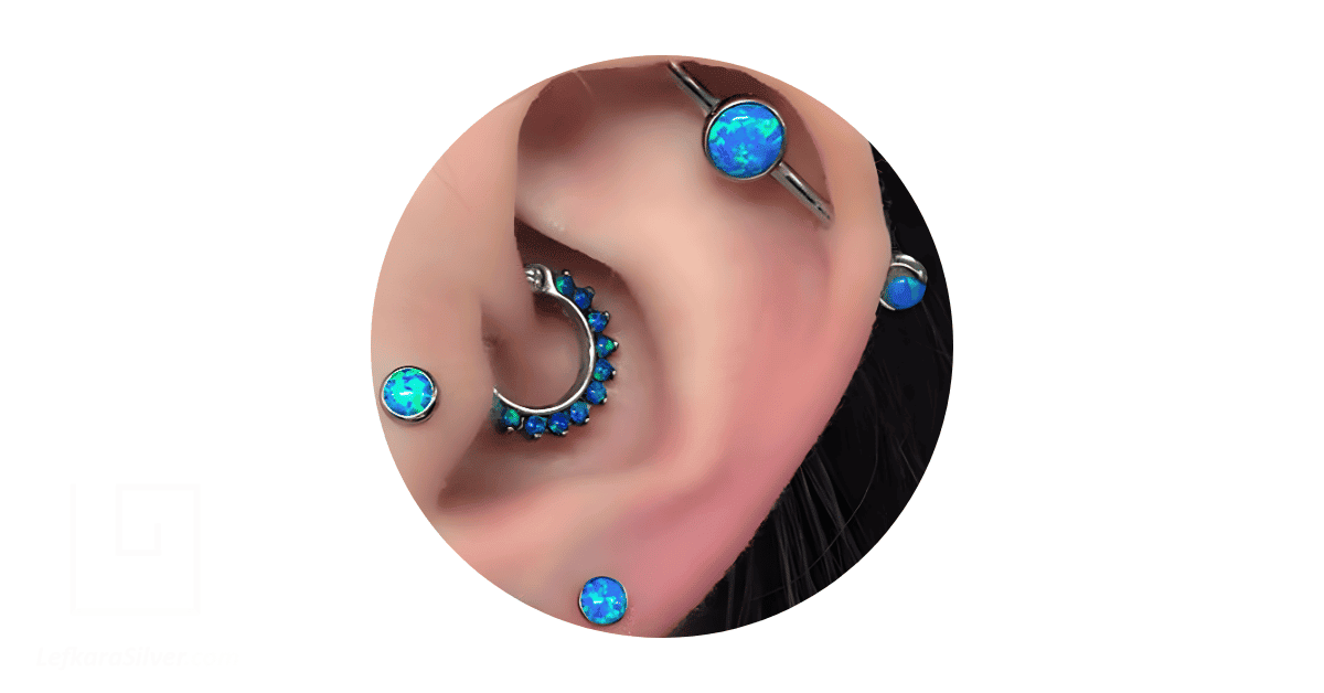 A woman's nose adorned with multiple opal body jewelry.