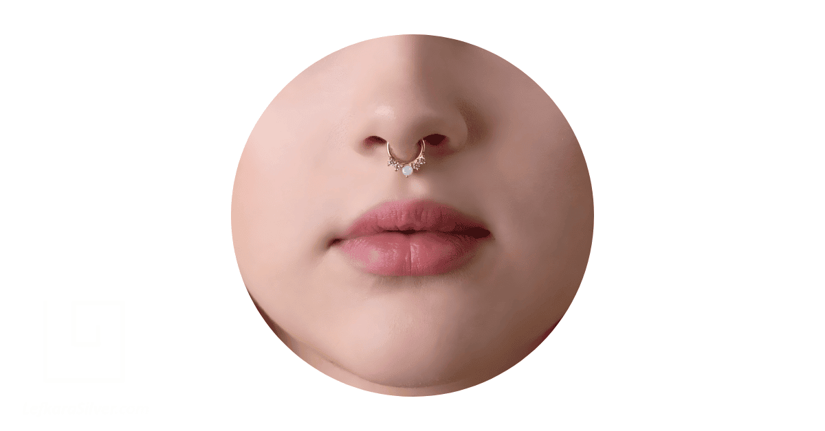 A woman's nose adorned with an opal septum piercing jewelry.