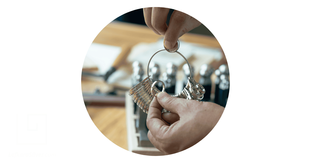 A person holding a US Ring Size Conversion tool