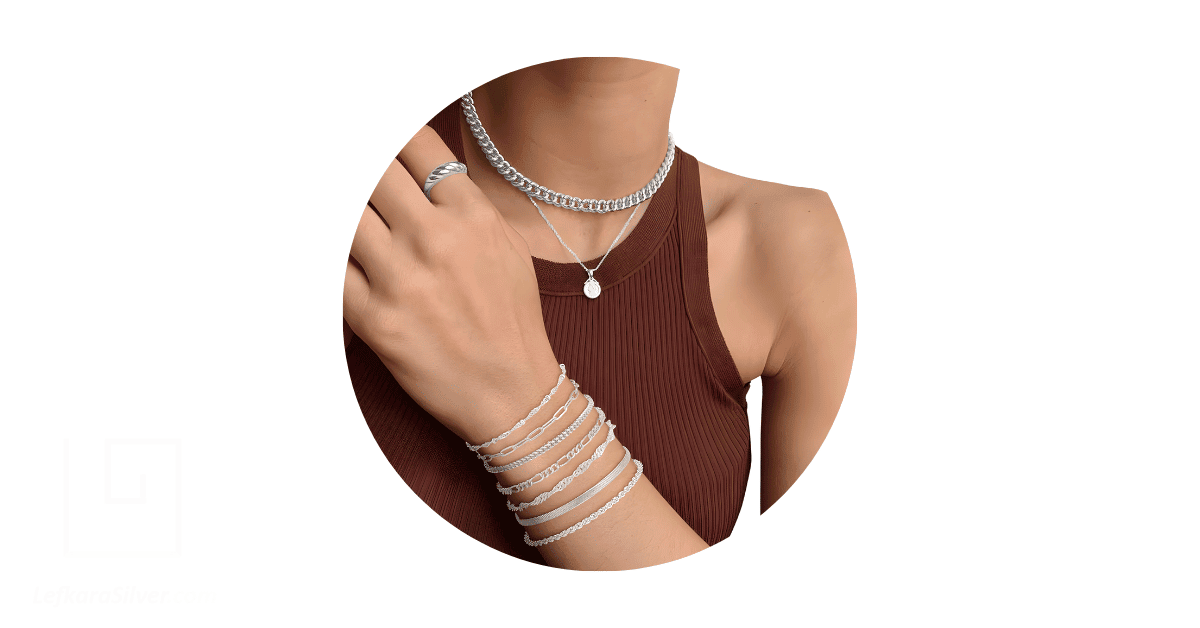 a person wearing a stack of silver jewelry.