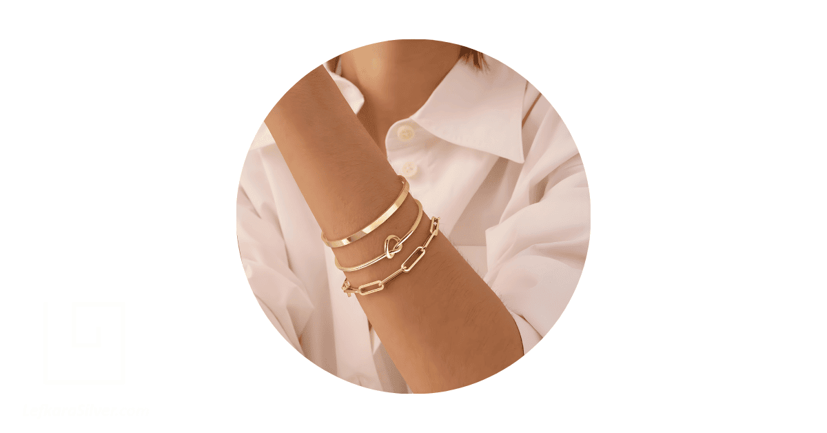 a person's wrist adorned with a stack of bracelets.
