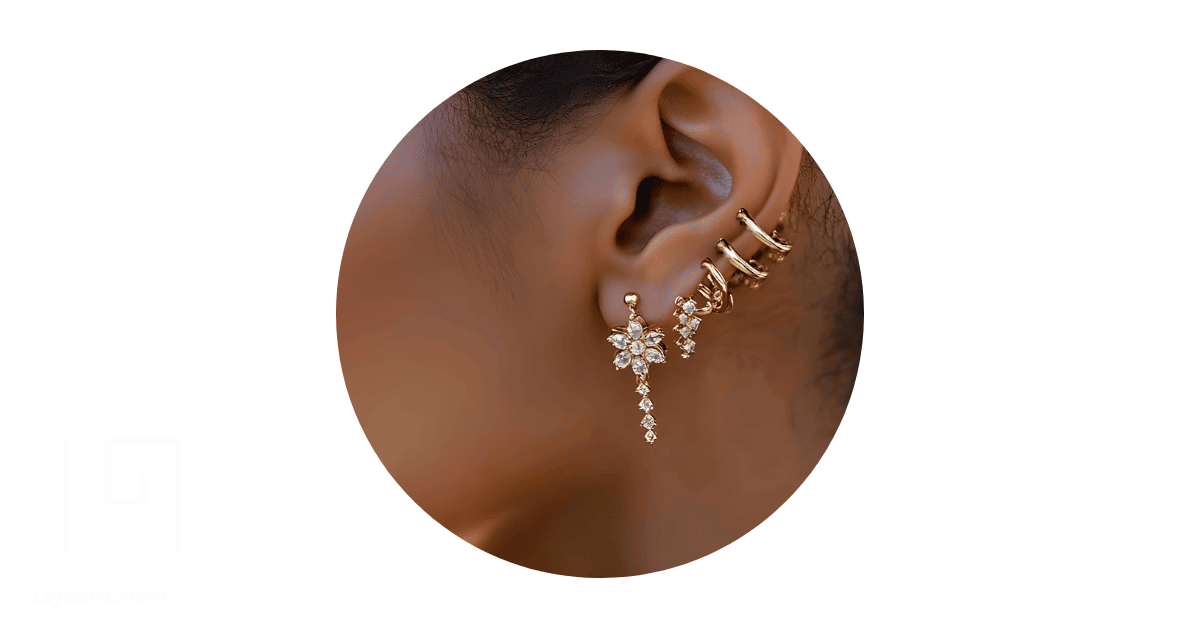 a person's ear adorned with multiple earrings.