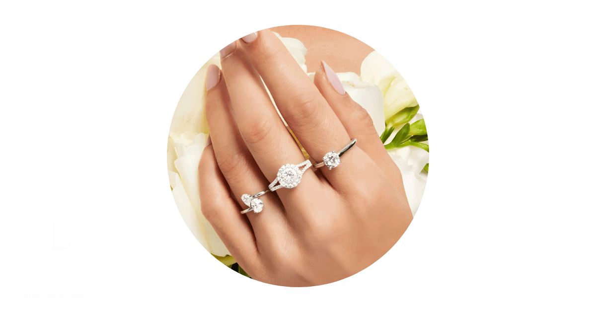 A person's hand adorned with different moissanite rings. 