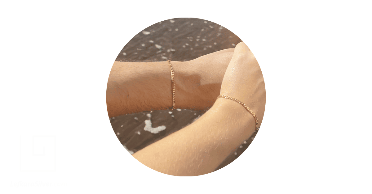 A couple wearing matching permanent bracelets. 