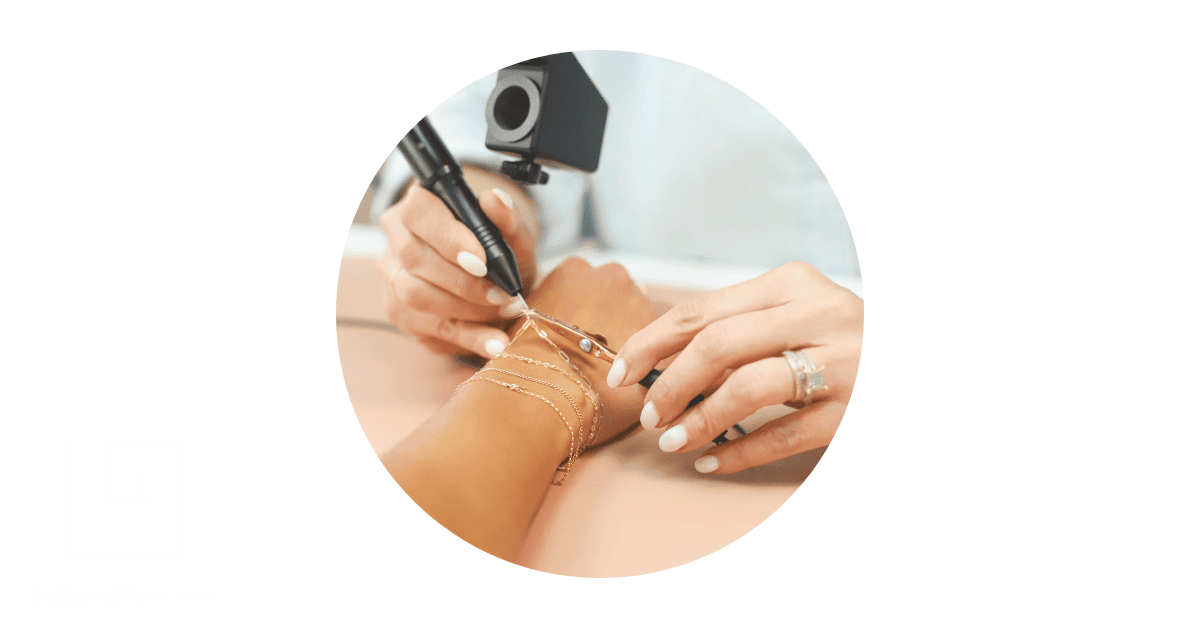 a jeweller zapping a permanent bracelet on a client's wrist.