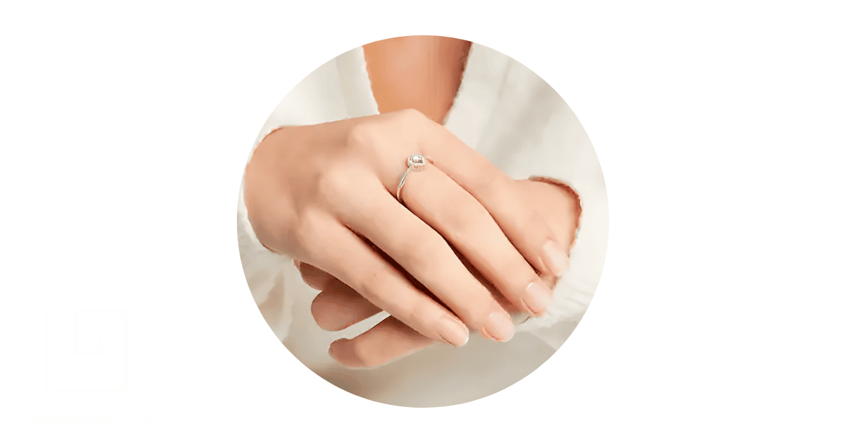 a person's hand with a promise ring on the 3rd finger of their right hand. 