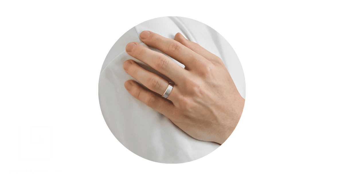a man's hand with a wedding ring on it.