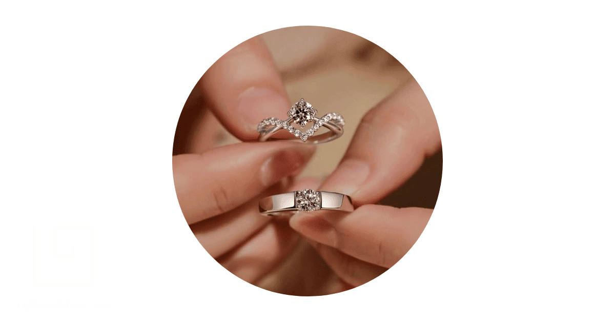 A person's hand holding a matching wedding ring set.