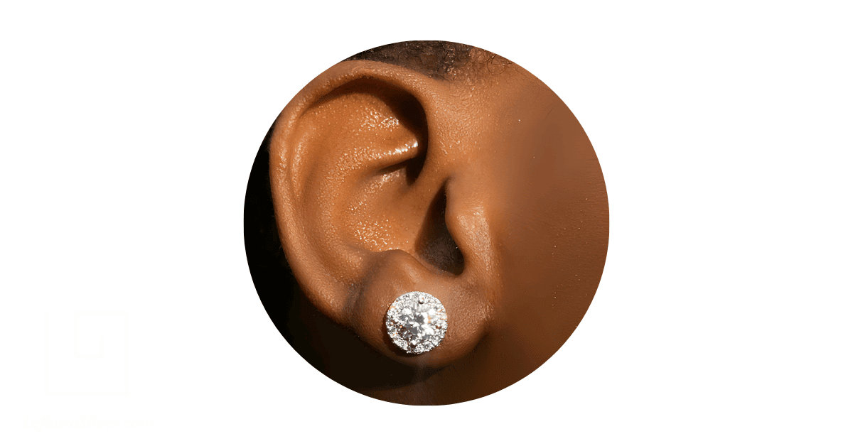 a person's ear adorned with a stud diamond earring.