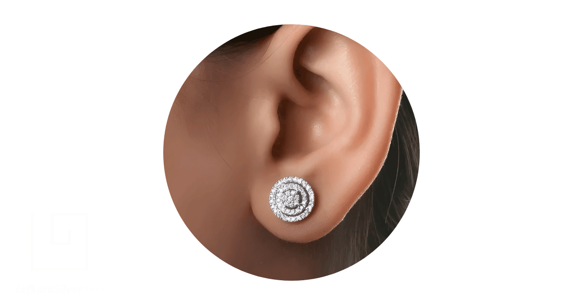 A person's ear adorned with a diamond stud earring.