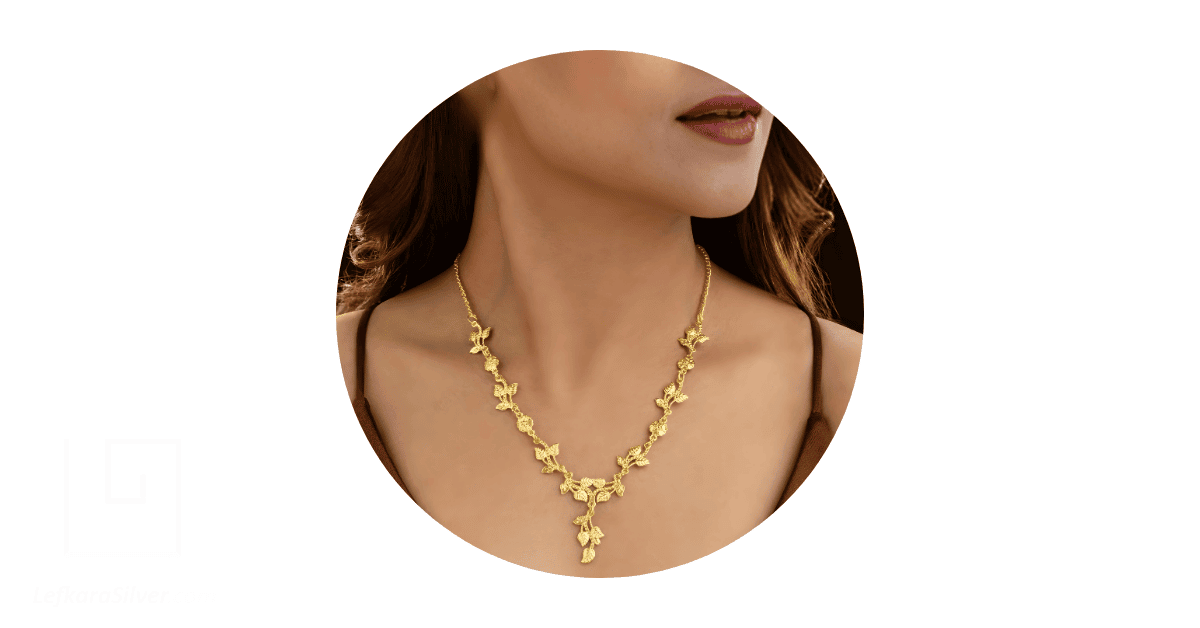 A woman's neck adorned with a beautiful solid gold necklace.
