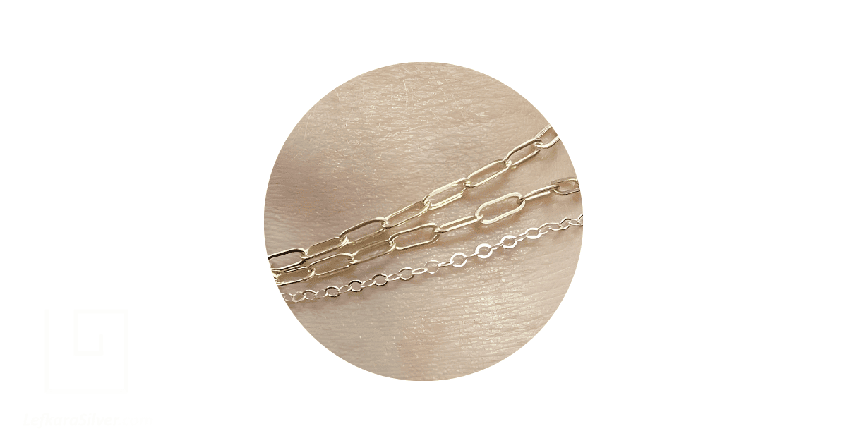 a person's wrist adorned with gold and silver permanent bracelets.