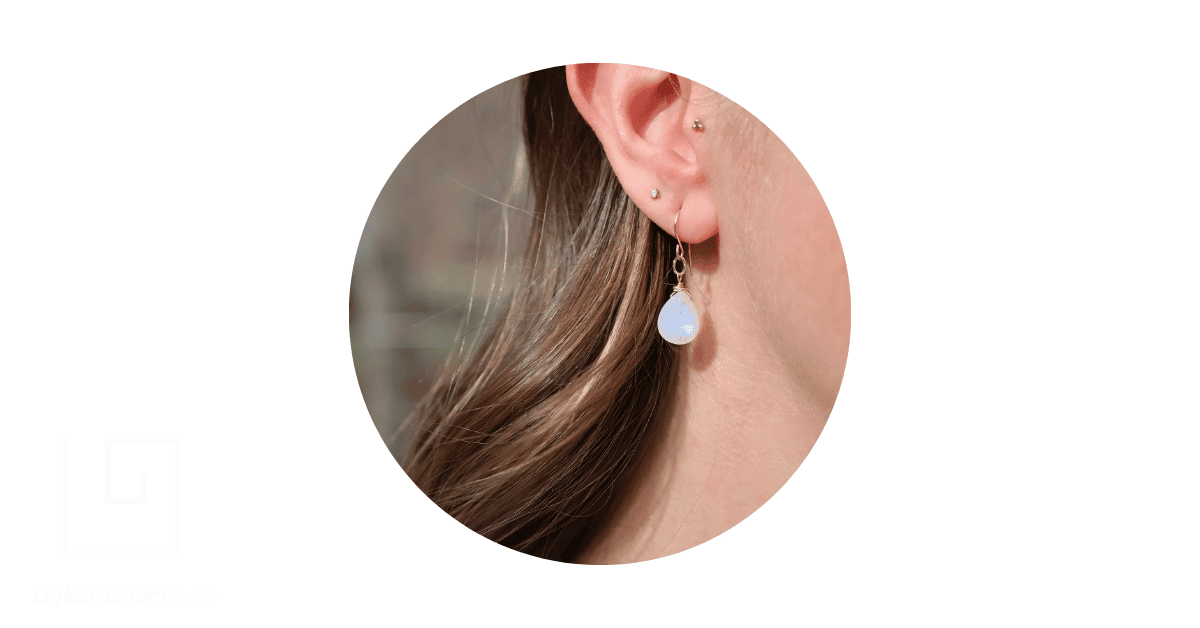 a person wearing a moonstone earring. 