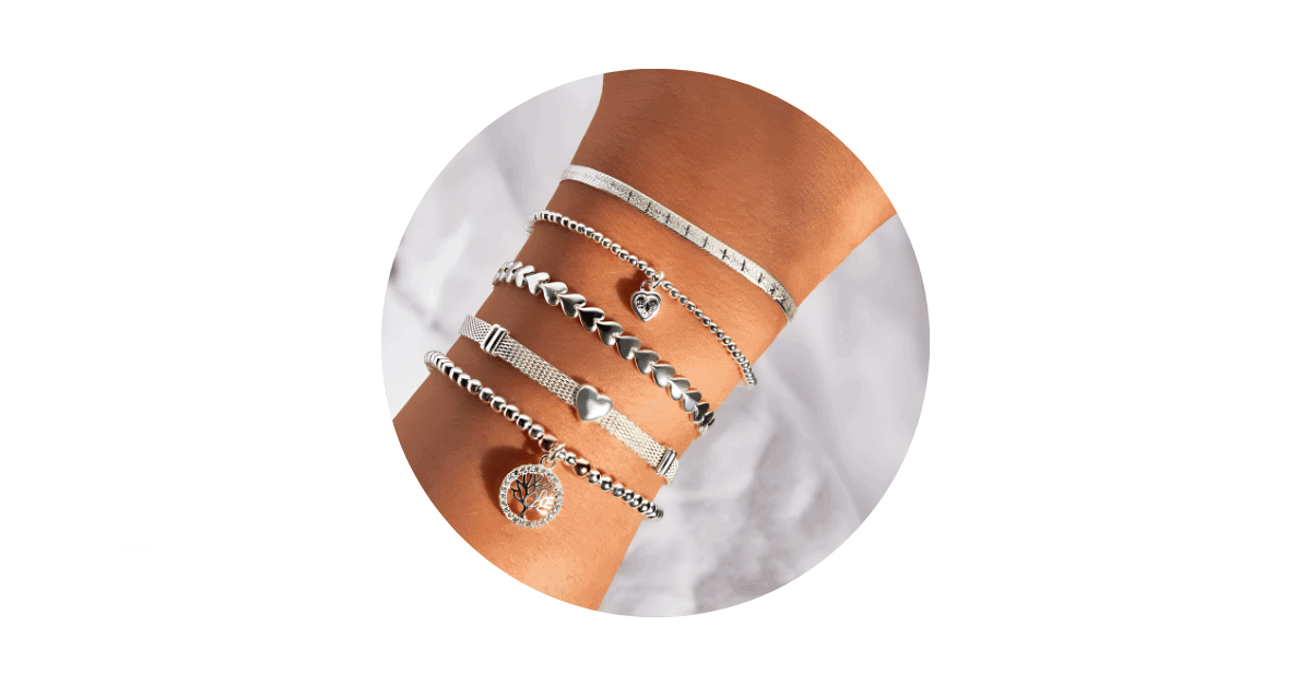 a person's wrist stacked with sterling silver bracelets. 
