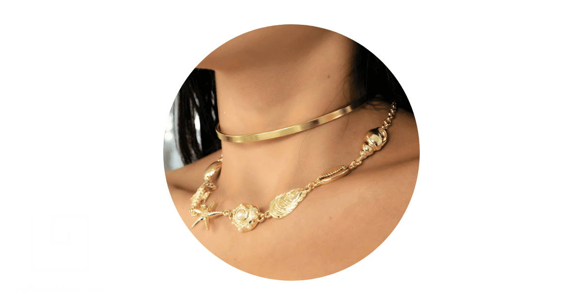 A woman's neck adorned with statement gold necklaces.