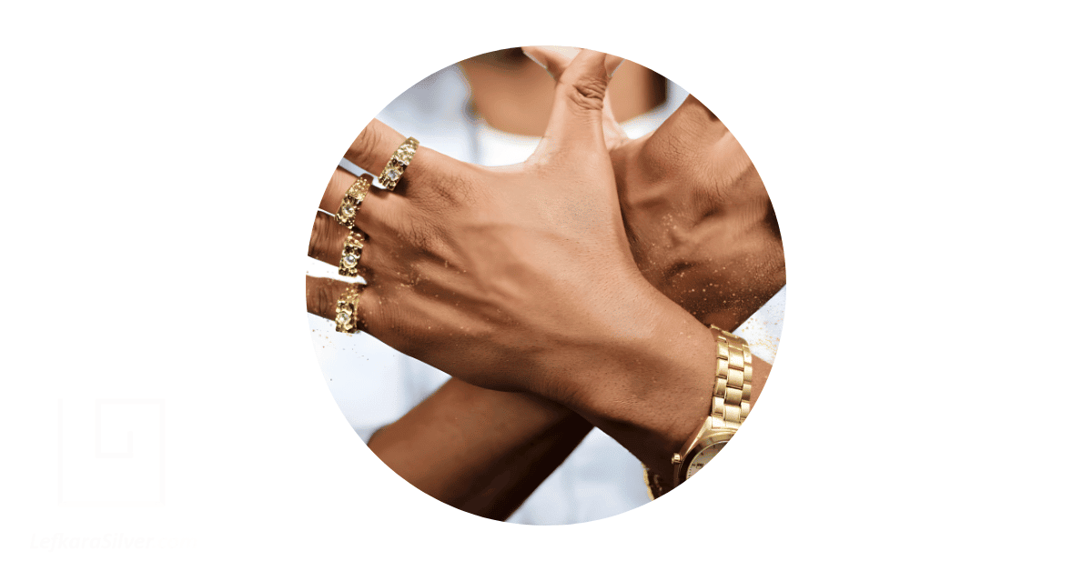 A man's fingers adorned with solid gold rings.