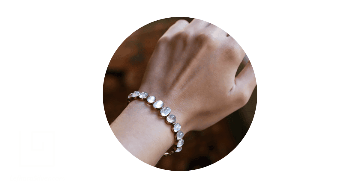 a person's wrist adorned with a moonstone bracelet.