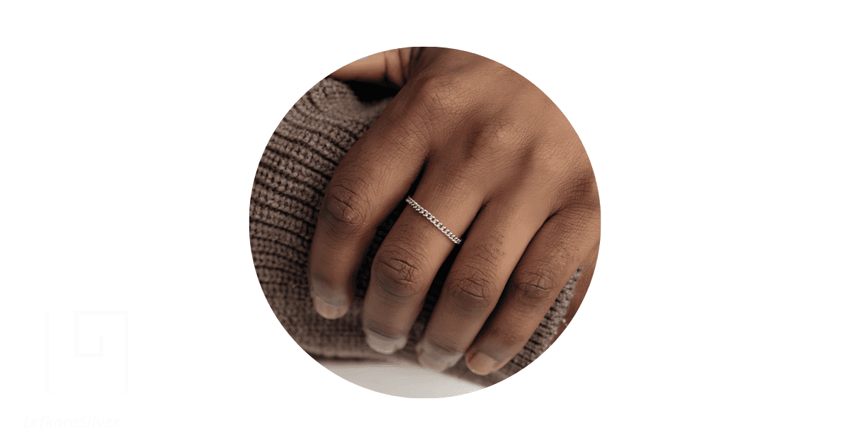 A man's finger adorned with a permanent ring. 