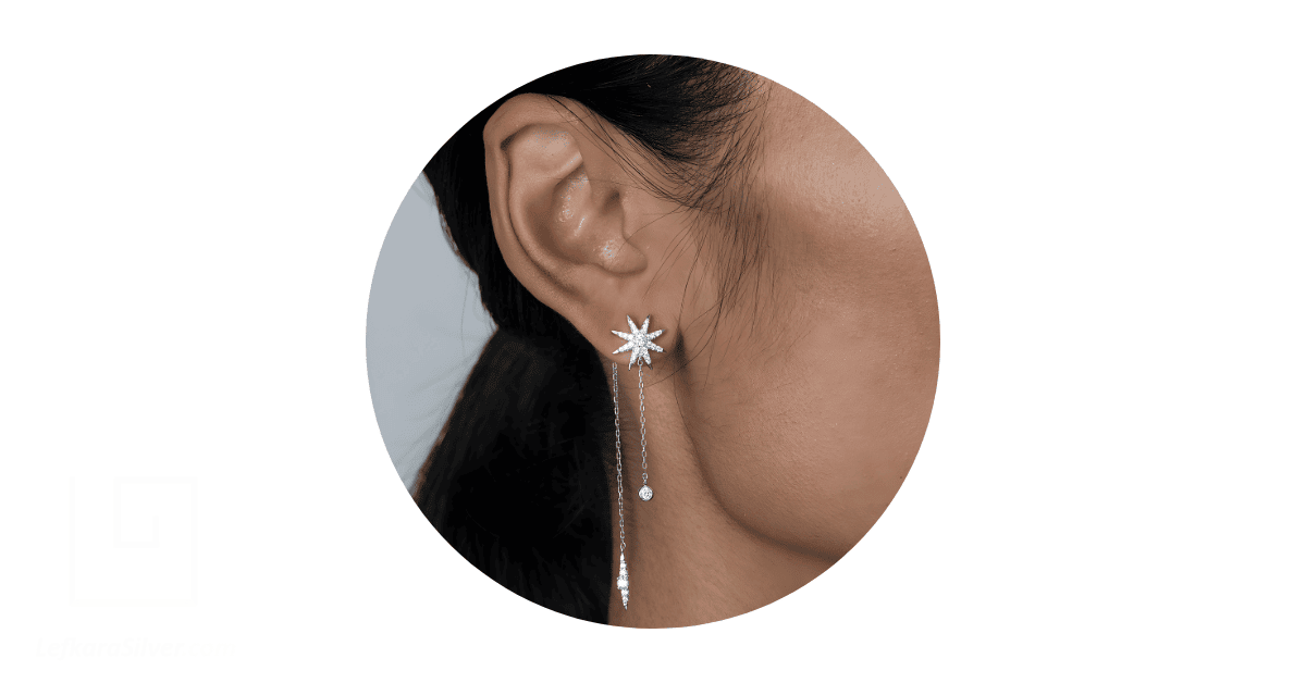 A woman's ear adorned with a sterling silver dangling earring