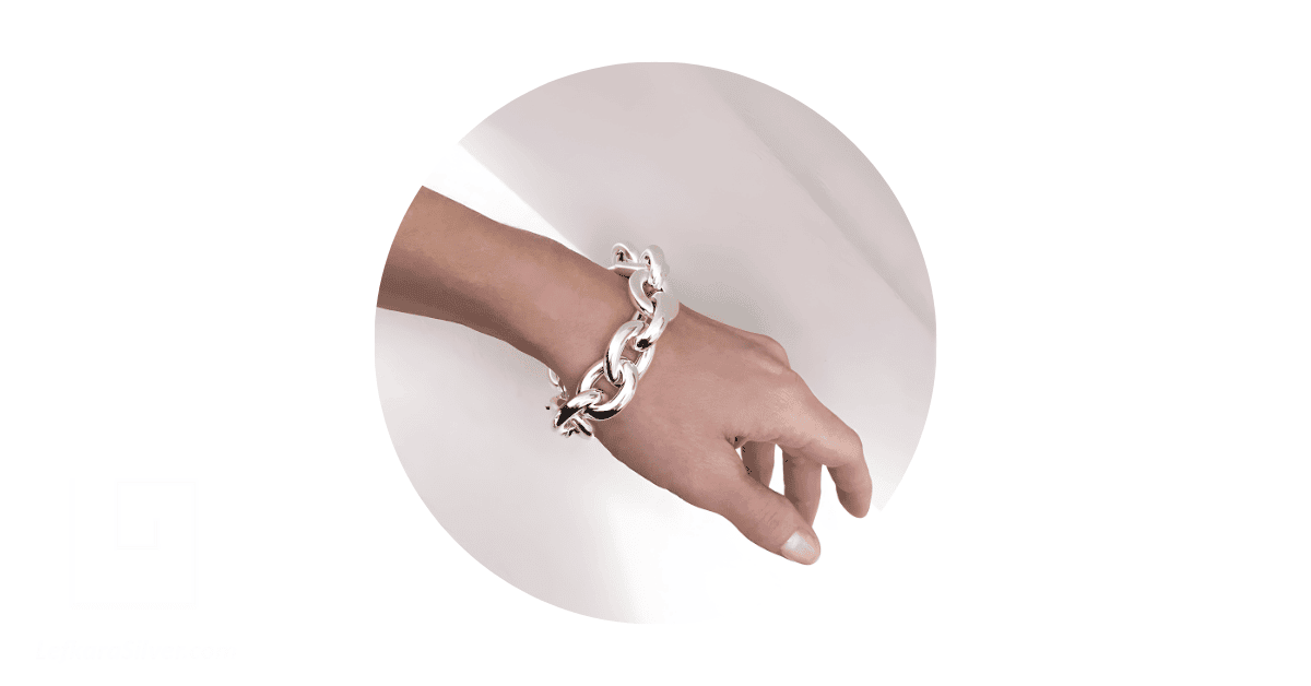 a person's wrist adorned with a chunky sterling silver bracelet. 
