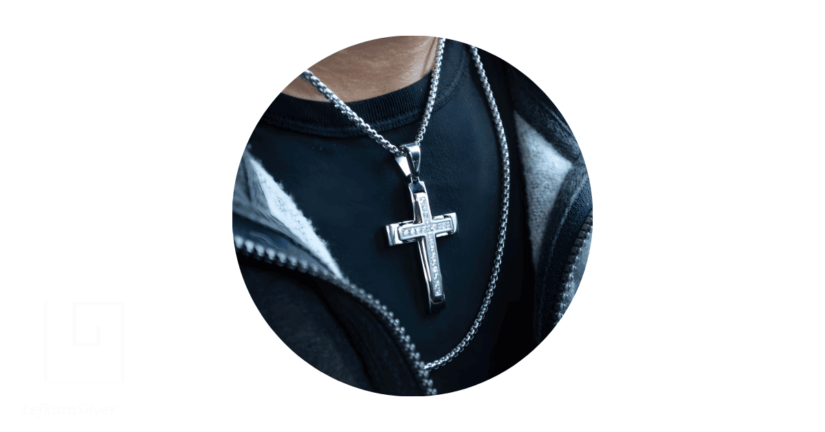 a man wearing a silver cross necklace.