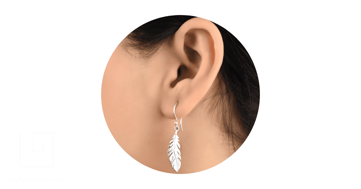 A woman's ear adorned with a sterling silver drop earring