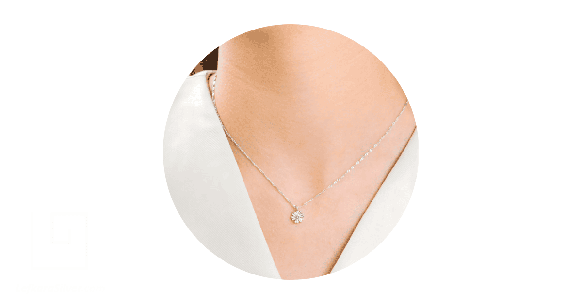 a person's neck adorned with dainty jewelry. 