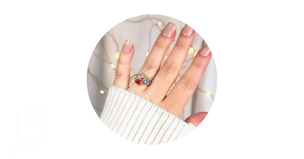 A woman's hand showing her fingers with a birthstone ring on. 