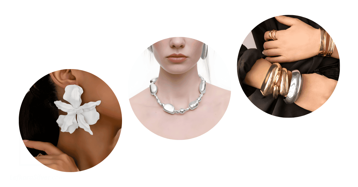 A person's ear adorned with a big, flowery earring, another person's neck adorned with a bold, sterling silver necklace, and someone's wrists adorned with chunky gold and silver bangles.