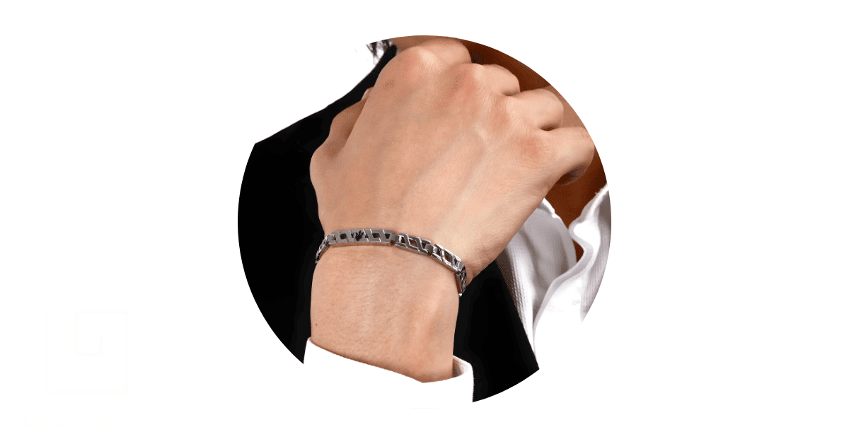 A man's wrist adorned with a steel bracelet.